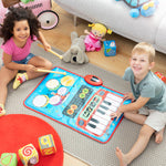Two children playing with a musical mat on the floor surrounded by toys.